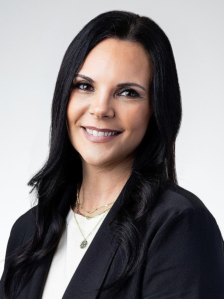 Professional woman smiling in business attire.