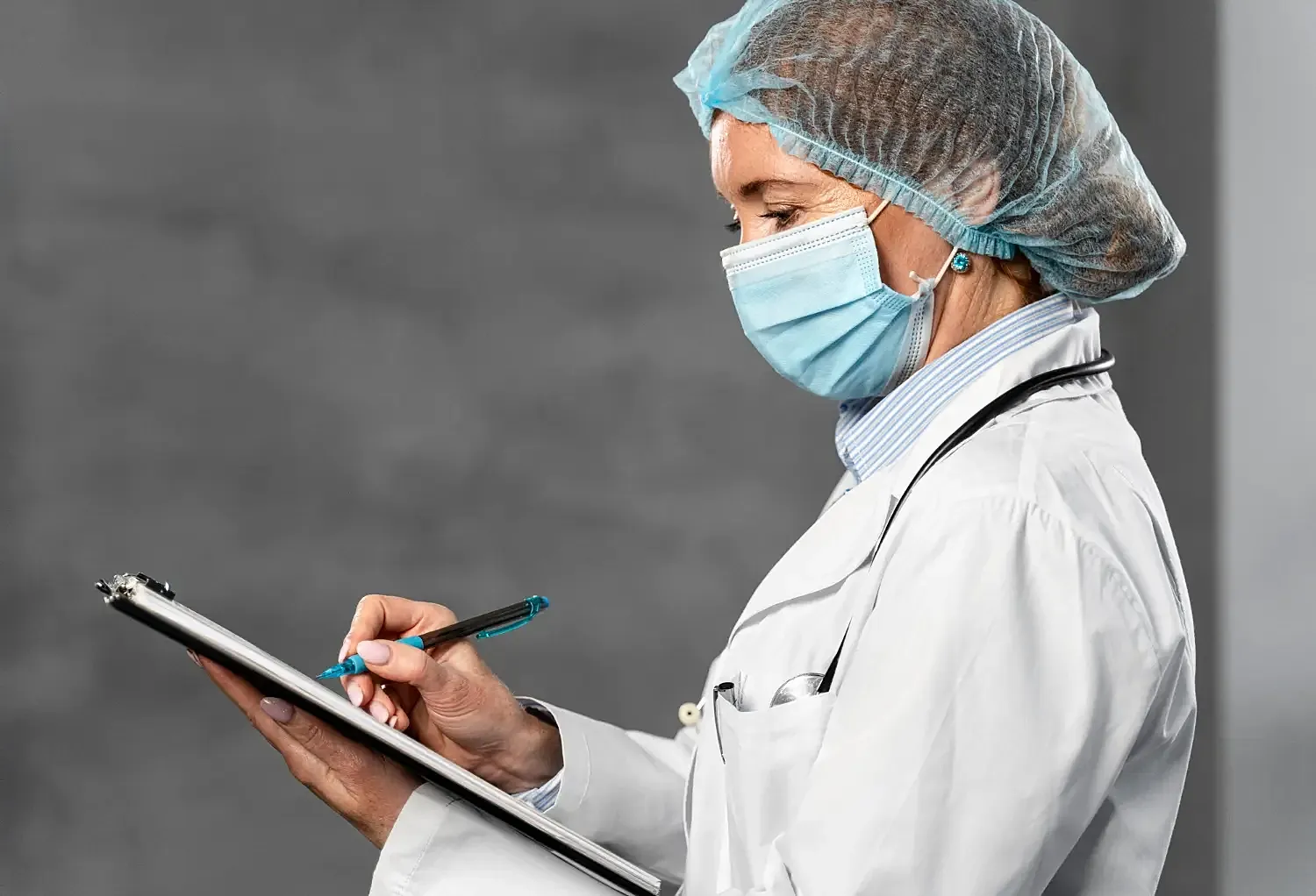 Healthcare professional writing on clipboard.