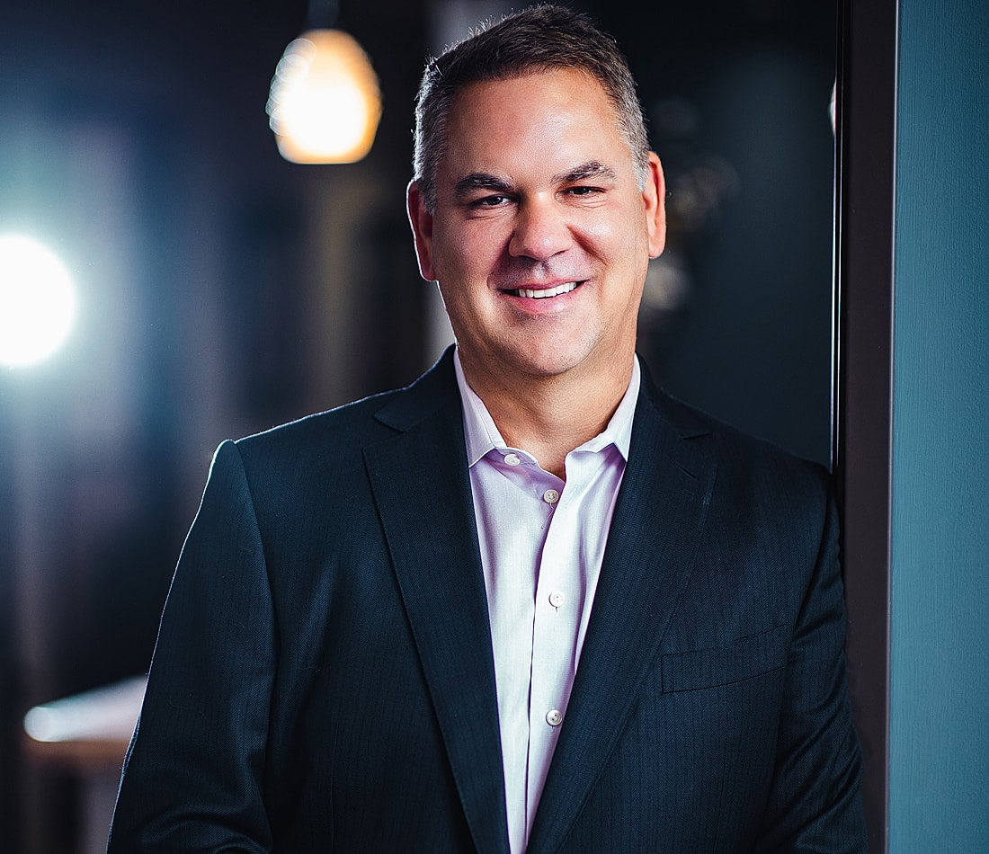 Smiling man in a business suit indoors.