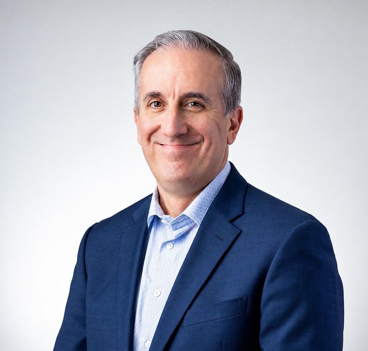 Smiling man in a blue suit, professional portrait.