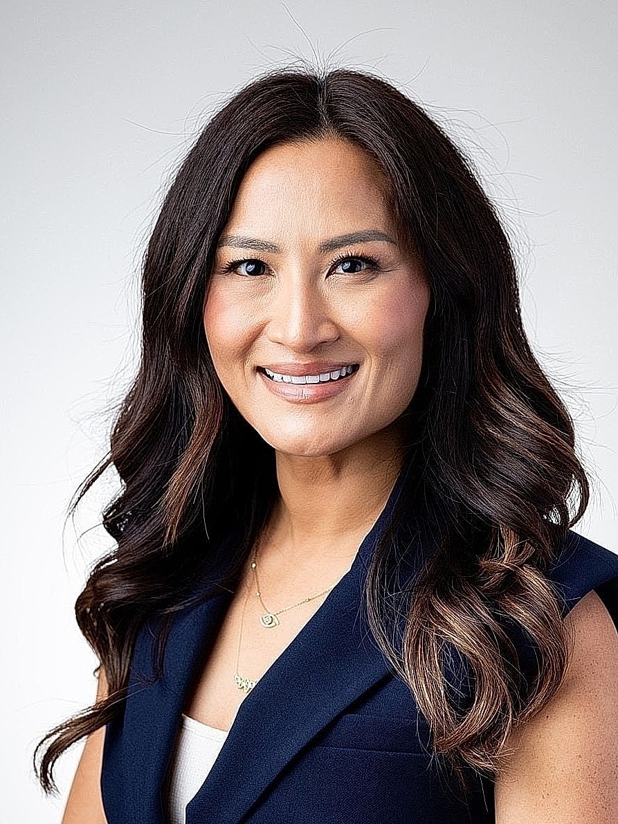 Professional woman smiling in formal attire.