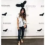 Person posing in front of branded backdrop.