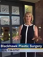 Woman in front of Blackhawk Plastic Surgery clinic.