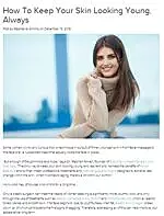 Woman smiling with healthy skin in a cozy sweater.