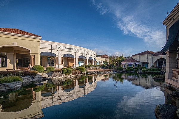 Blackhawk Plastic Surgery building exterior reflected in pond with landscaping and blue sky