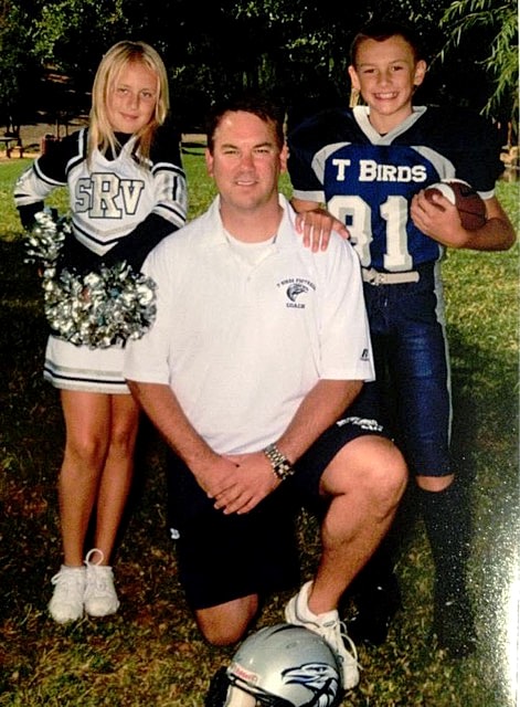 Dr. Stephen Ronan with two young athletes at a community sports event