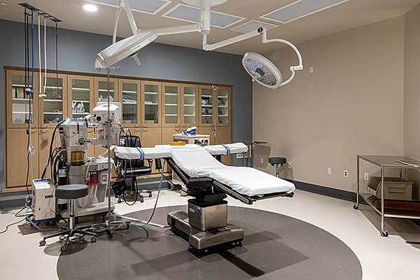 Modern surgical operating room with sterile equipment, surgical lights, and examination table at Blackhawk Surgery Center
