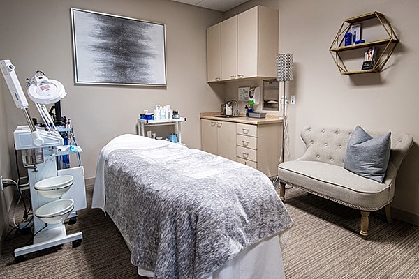 Spa treatment room with treatment bed and equipment.