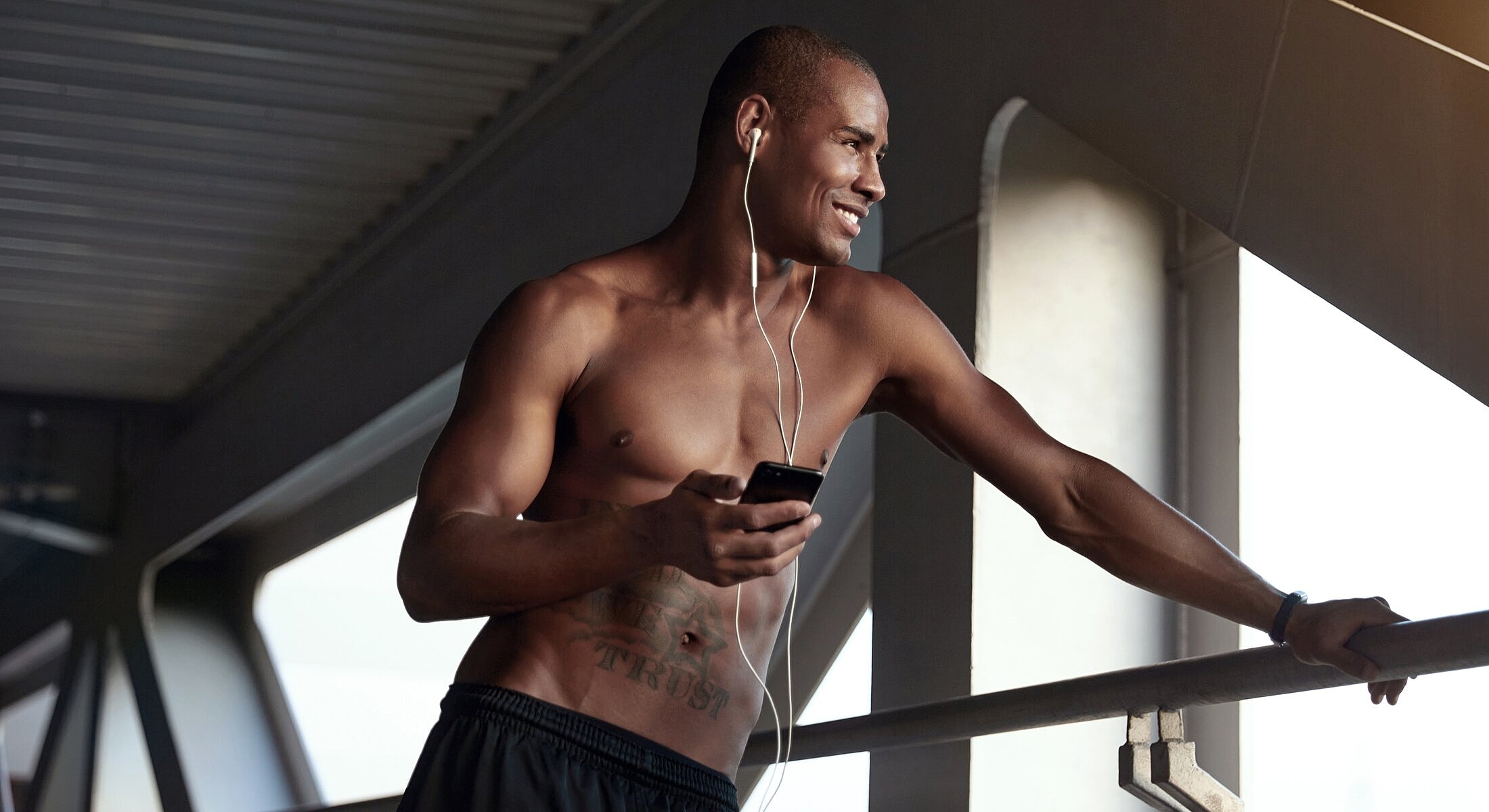 Man listening to music and smiling indoors.