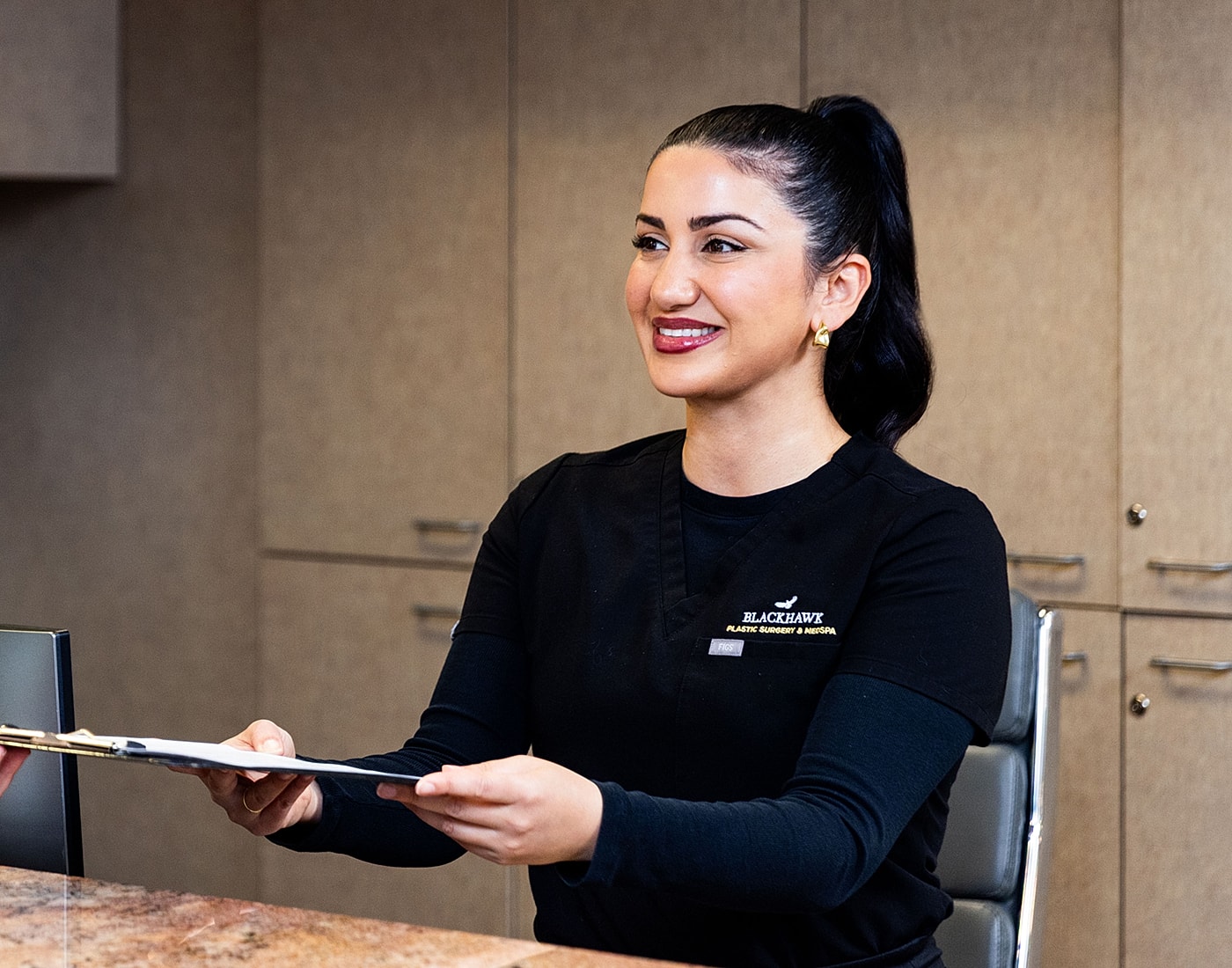 Smiling professional handing over a clipboard.